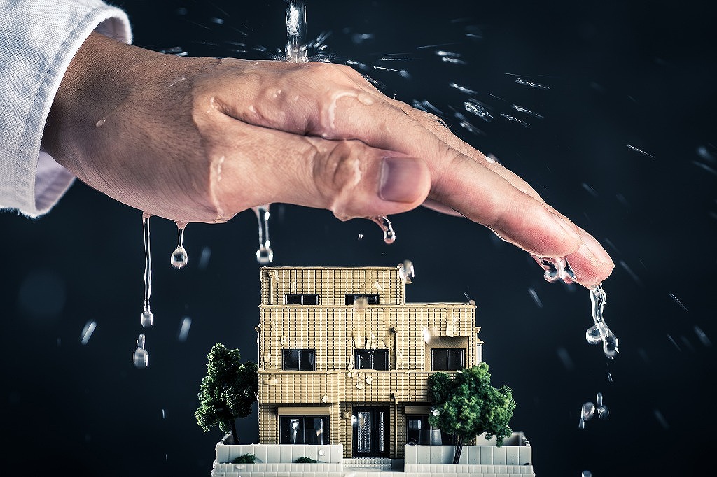 家の模型と水を防ぐ手